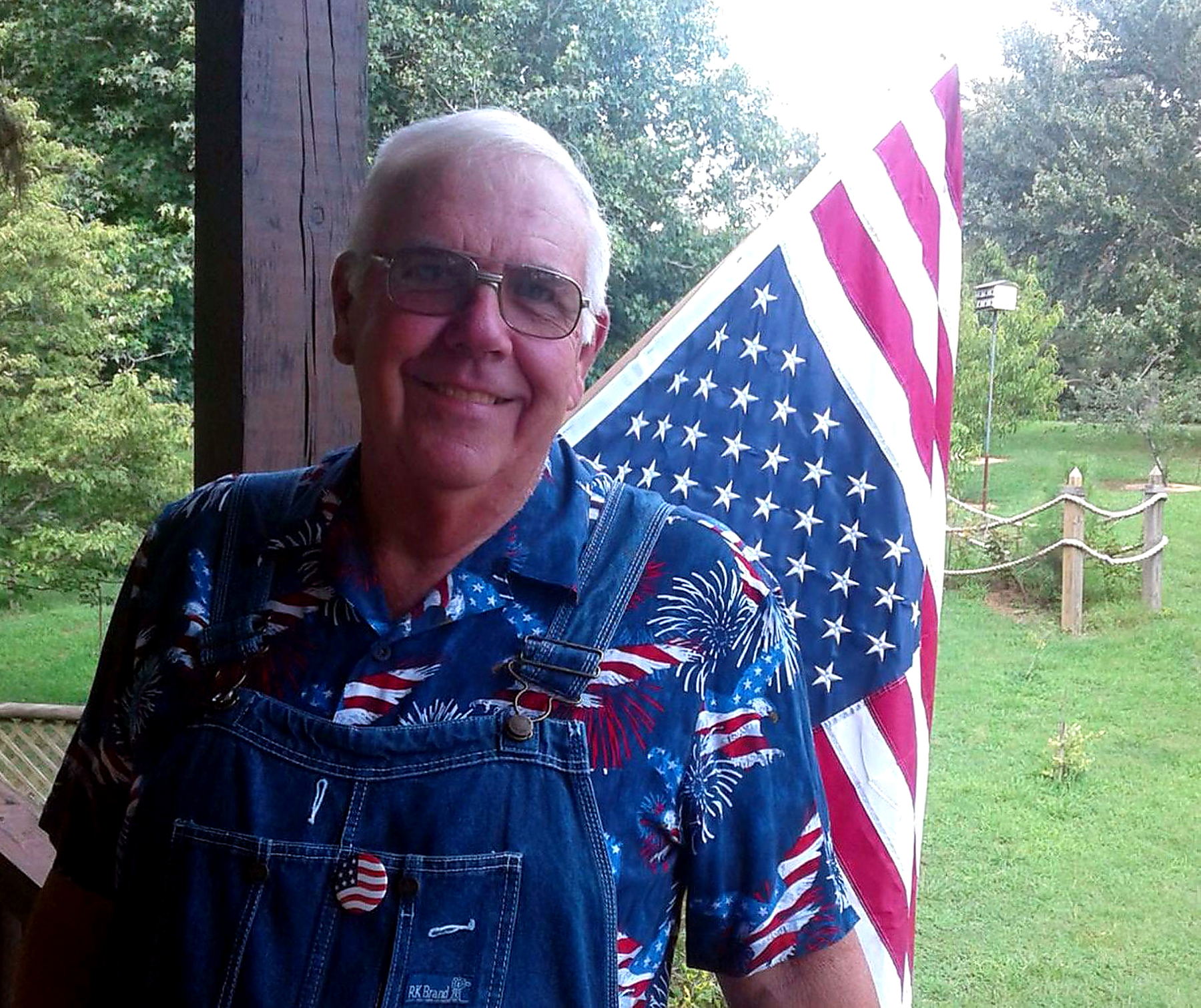Uncle Wisdom standing beside the American flag